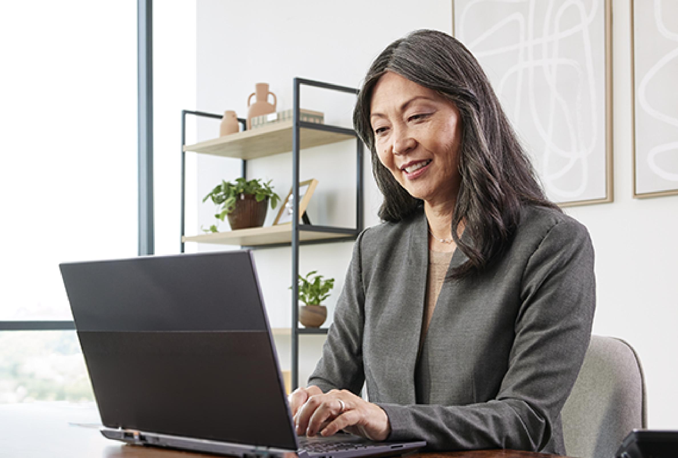 woman sitting at a desk working on a laptop